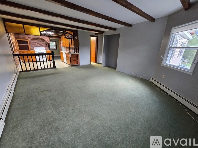 A spacious room with a balcony and a window.