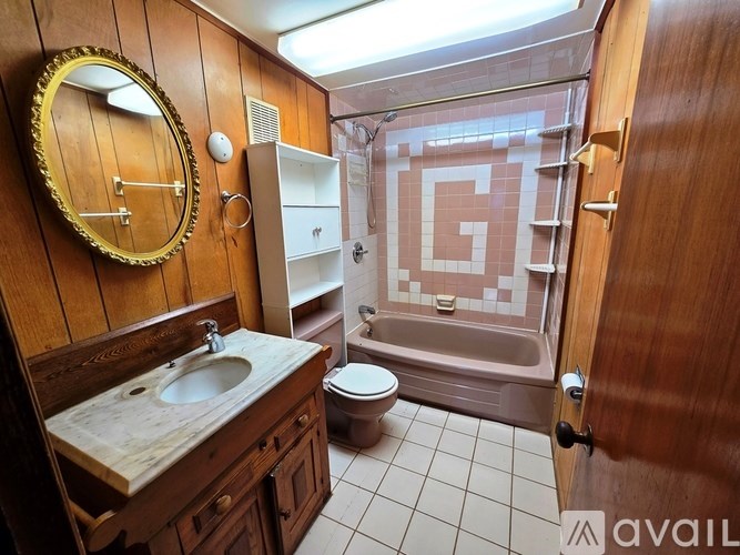 A bathroom with a wooden vanity and a walk-in shower.