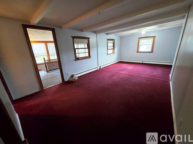 A room with a red carpet and a window.