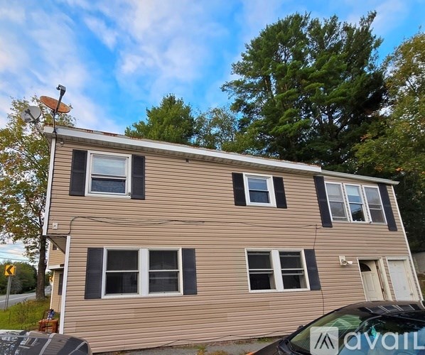 A two-story house with a beige siding and multiple windows.