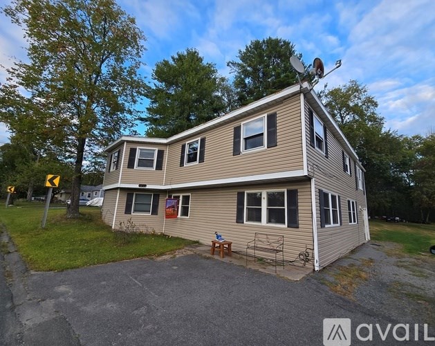 A house with a satellite dish on the roof and a yellow sign on the left.