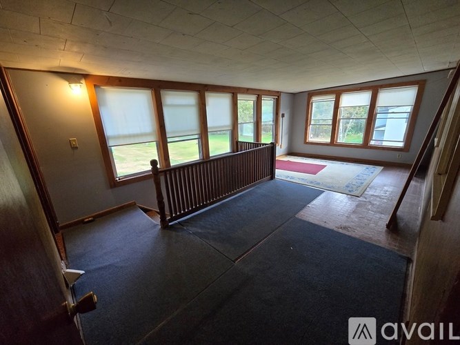 A room with a window overlooking a field.