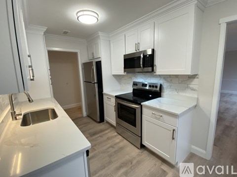 A kitchen with white cabinets and a black stove top oven.