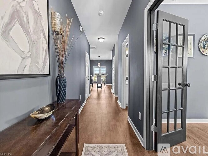 A hallway with a wooden floor and a large painting on the wall.