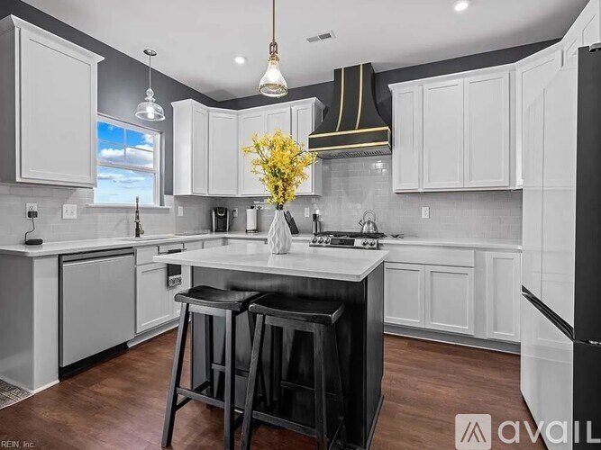 A kitchen with white cabinets and a black stove top oven.