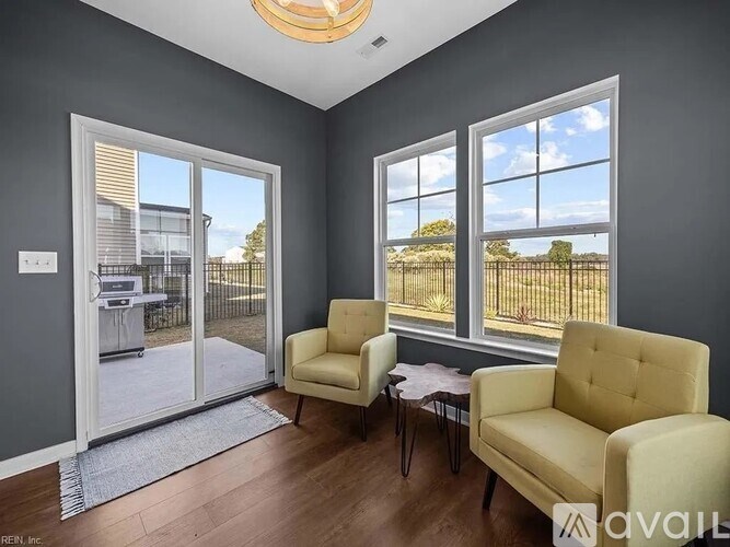 A living room with a yellow chair and a table in front of a window.