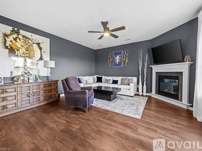 A living room with a purple chair and a fireplace.