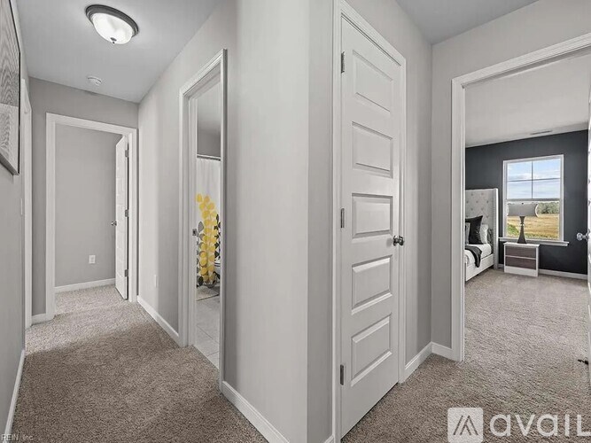 A white door is open to a hallway with a carpeted floor.