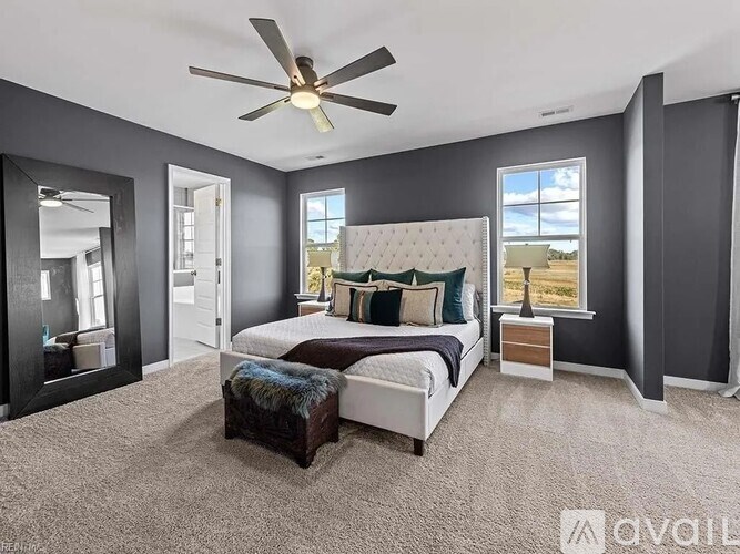 A bedroom with a large bed and a ceiling fan.