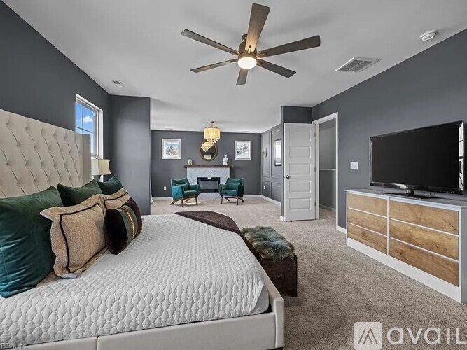 A bedroom with a large bed, a ceiling fan, and a television.