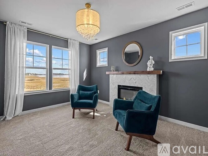 A living room with a fireplace and two chairs.