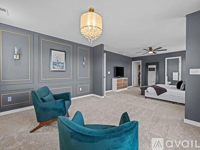 A living room with a green velvet chair and a white bed.