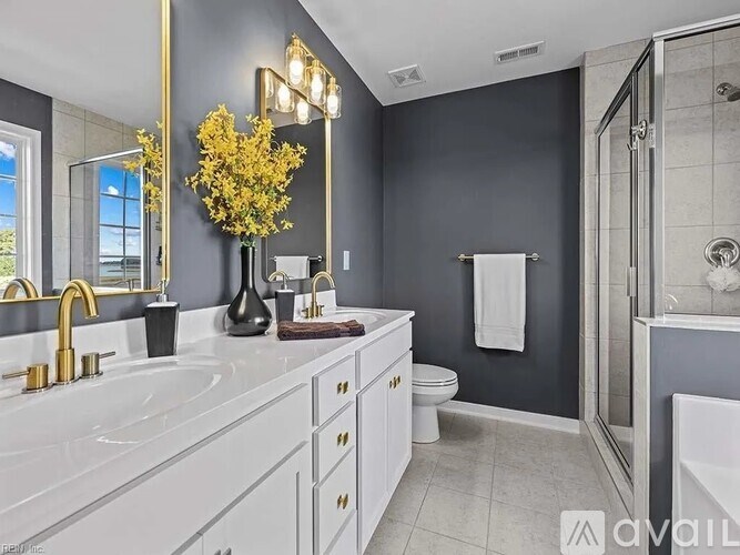 A bathroom with a white countertop and a gold faucet.