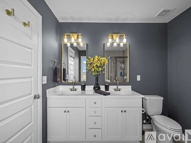A bathroom with two sinks and a toilet.