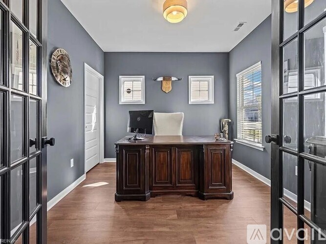 A home office with a wooden desk and a computer on it.