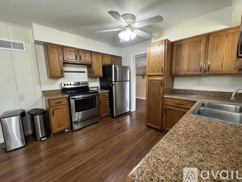 A kitchen with wooden cabinets and a granite counter top.