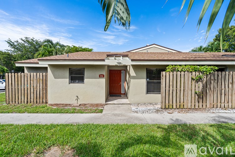 A house with a red door and a brown fence.