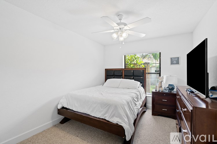 A bedroom with a bed, nightstand, and television.