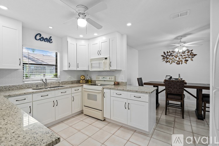 A kitchen with white cabinets and granite countertops.