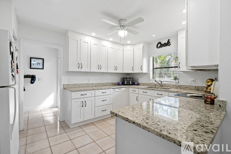 A kitchen with granite countertops and white cabinets.