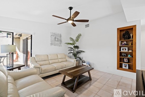 A living room with a white sofa and a wooden coffee table.