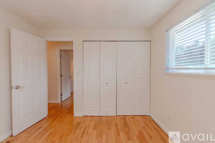 A room with white doors and wooden floors.