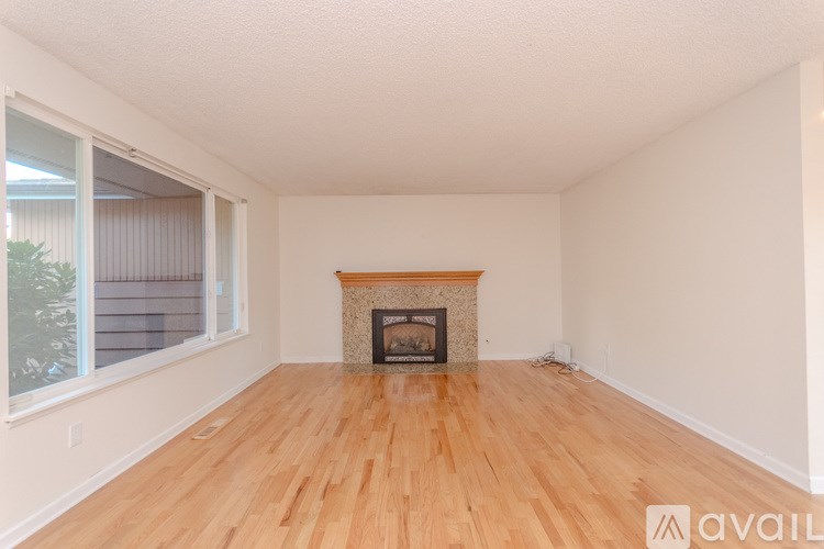 A room with a fireplace and wooden flooring.