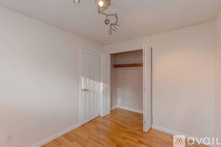 A room with a white door and a wooden floor.