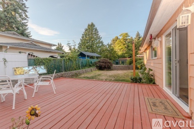 A small orange house with a white door and windows, surrounded by greenery and a clear sky.