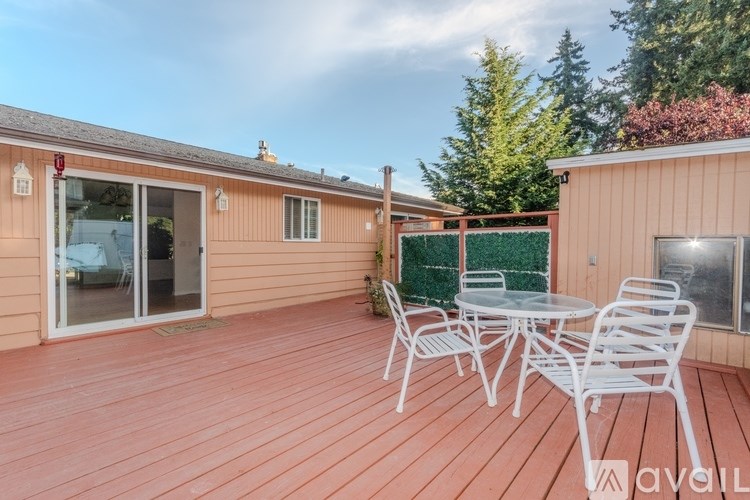 A wooden deck with a table and chairs is available for rent.