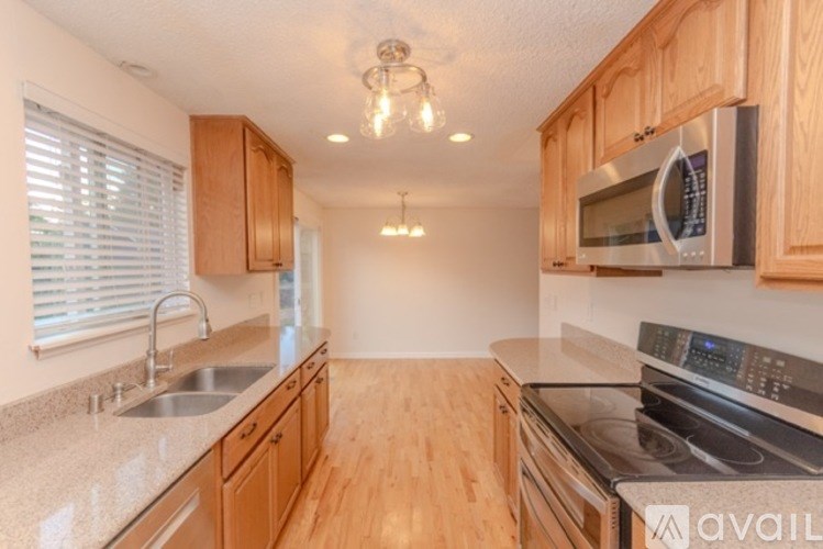 A kitchen with wooden cabinets and a granite countertop.