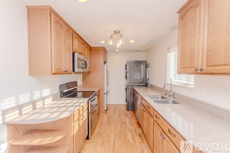 A kitchen with wooden cabinets and a granite countertop.