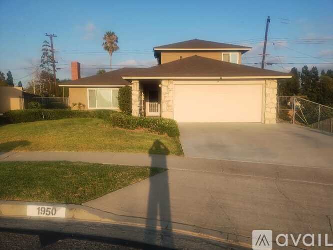 A house with a garage and a driveway in front of it.
