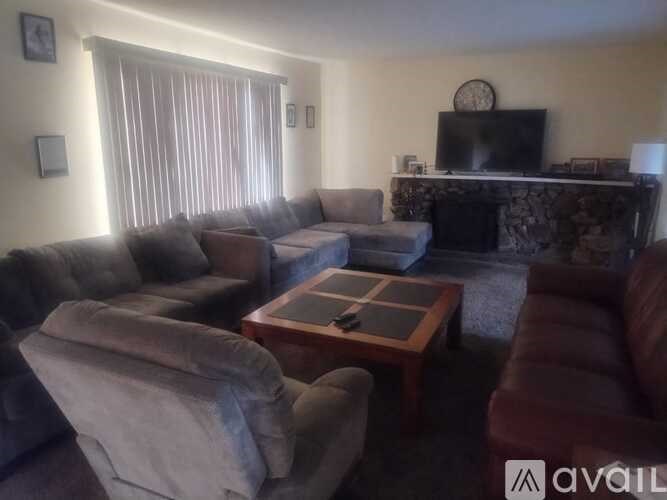 A living room with a grey couch, a red couch, and a coffee table.