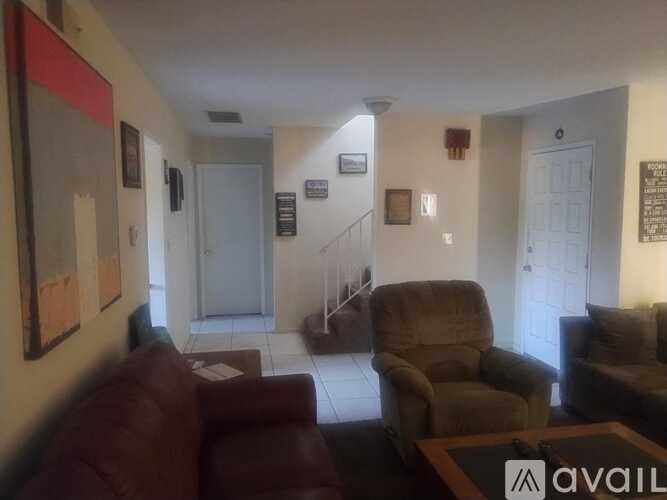 A living room with a brown couch and a chair.
