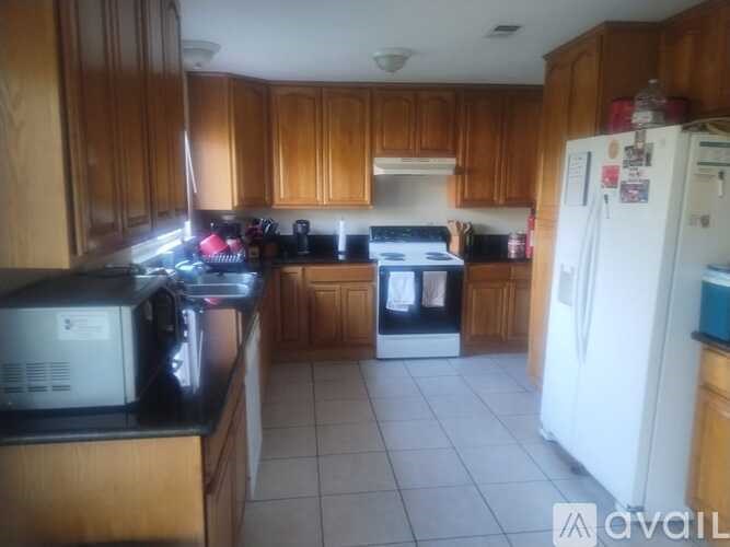 A kitchen with wooden cabinets and a white refrigerator.