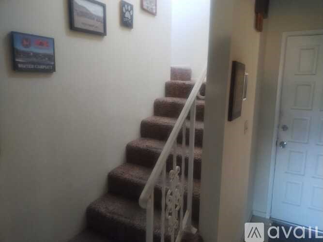 A staircase with a white railing and a white door.
