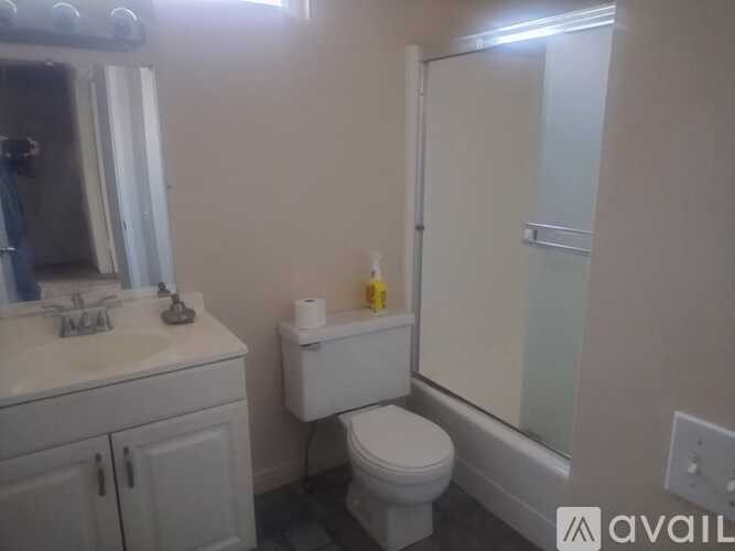 A bathroom with a toilet, sink, and shower.