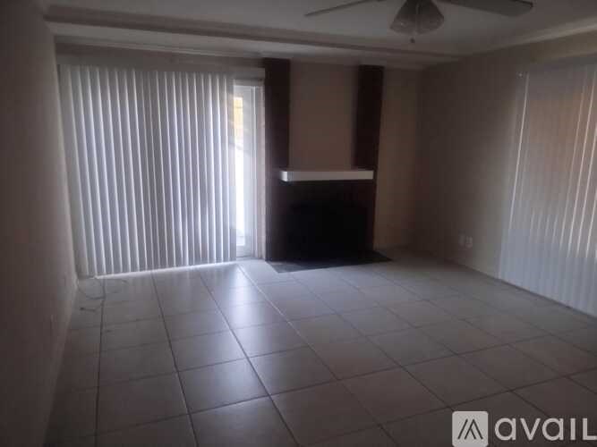 A room with a ceiling fan and tiled flooring.