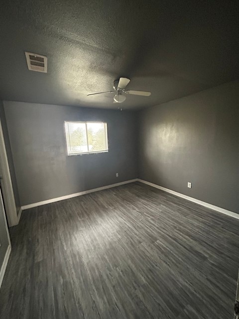 A room with a ceiling fan and a window.
