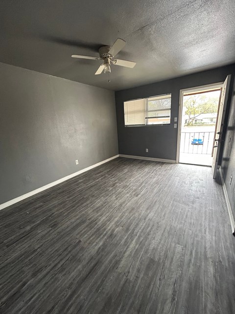 A room with a ceiling fan and a door leading outside.