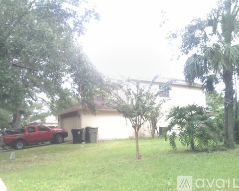 A red truck is parked in front of a house.