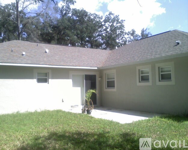 A house with a brown roof and a white wall with a window and a door.