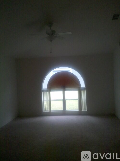 A room with a window and a ceiling fan.