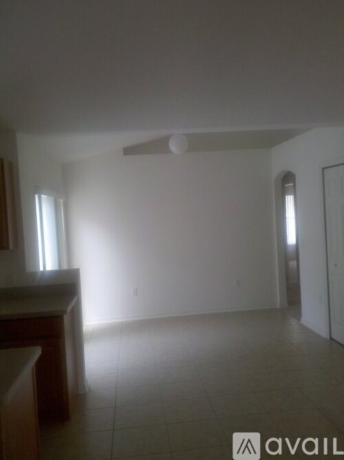 A room with a tiled floor and a window on the left side.