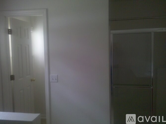 A white door is open to a dark room.