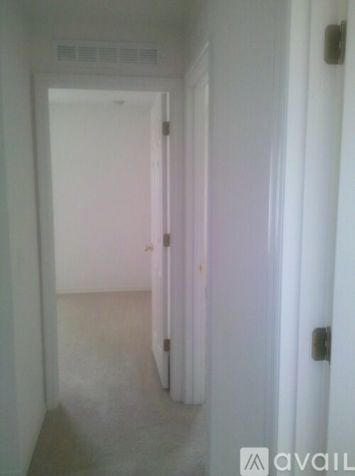 A hallway with a door on the right and a wall heater on the left.