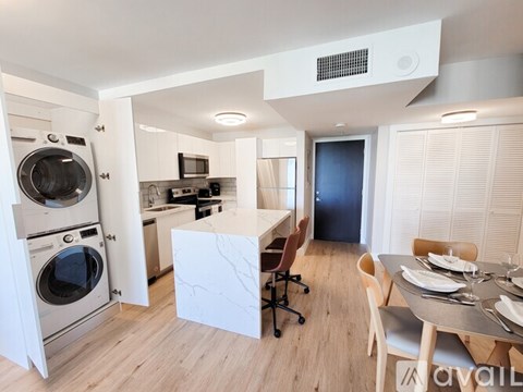 A modern kitchen with a dining table and chairs.