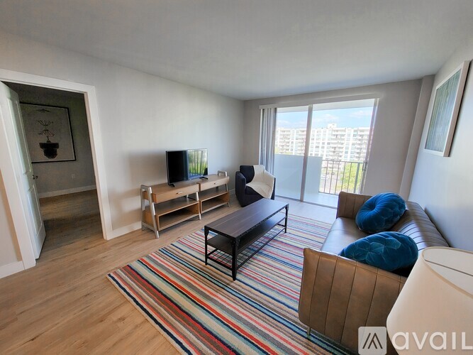 A living room with a striped rug and a brown sofa.