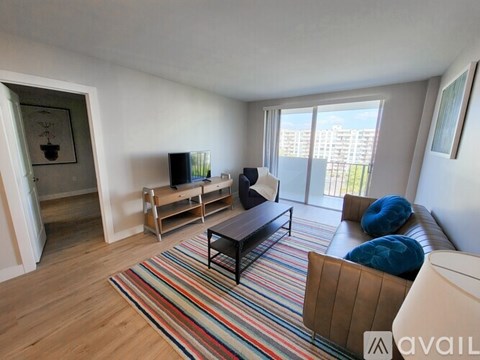 A living room with a striped rug and a brown sofa.